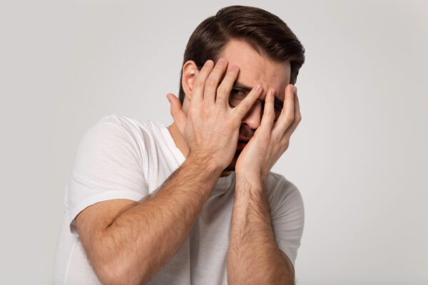 man covering face - deposit photos